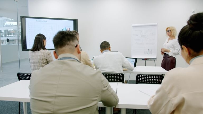 A business professional presenting in a modern, well-lit office environment.